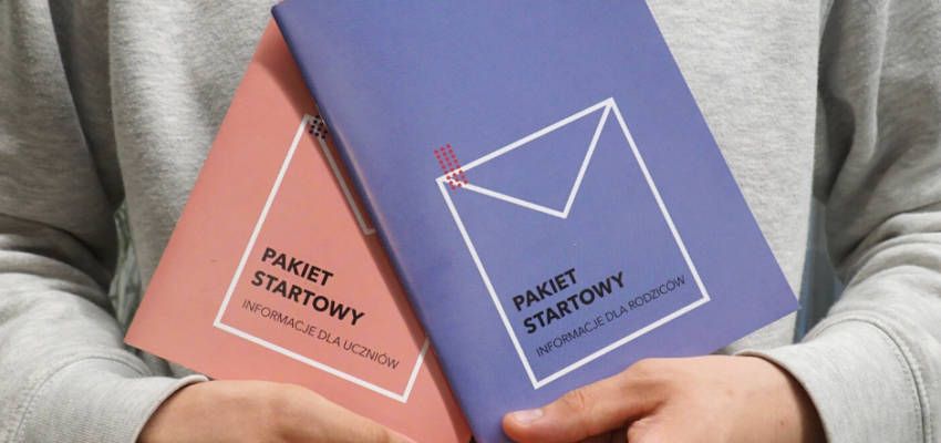 Zdjęcie przedstawia popiersie osoby w szarek bluzie, trzymająca w rękach dwie publikacje zatytułowane: Pakiet startowy.